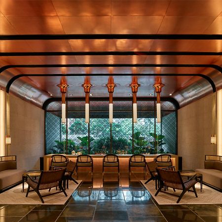 The Ruma Hotel And Residences Kuala Lumpur Exteriér fotografie The image shows a stylish interior space with a modern and elegant design. The walls have a sleek, warm-toned finish, and there are large windows that provide natural light. The ceiling features striking architectural lines, likely in a metallic mate