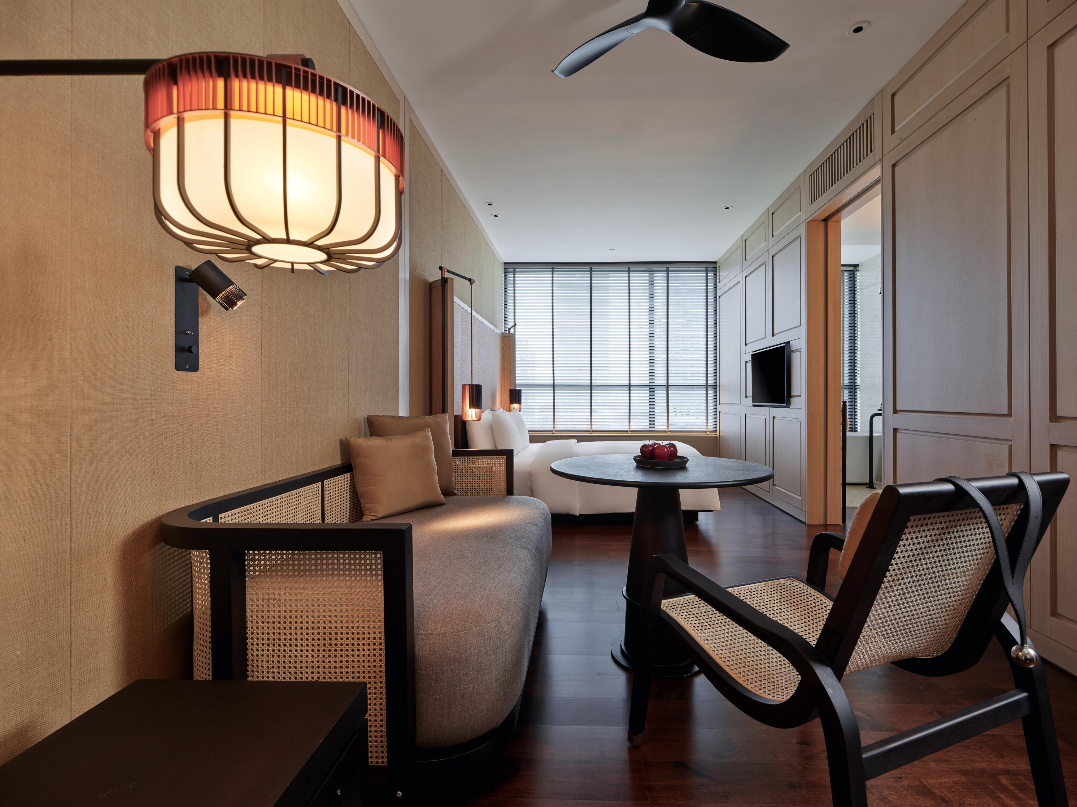 The Ruma Hotel And Residences Kuala Lumpur Exteriér fotografie The photo shows a stylish and modern interior of a hotel room or a living space. The decor features warm tones and natural materials, with a wall finished in light wood or beige. 

In the foreground, there is a round table with a small decorative ite