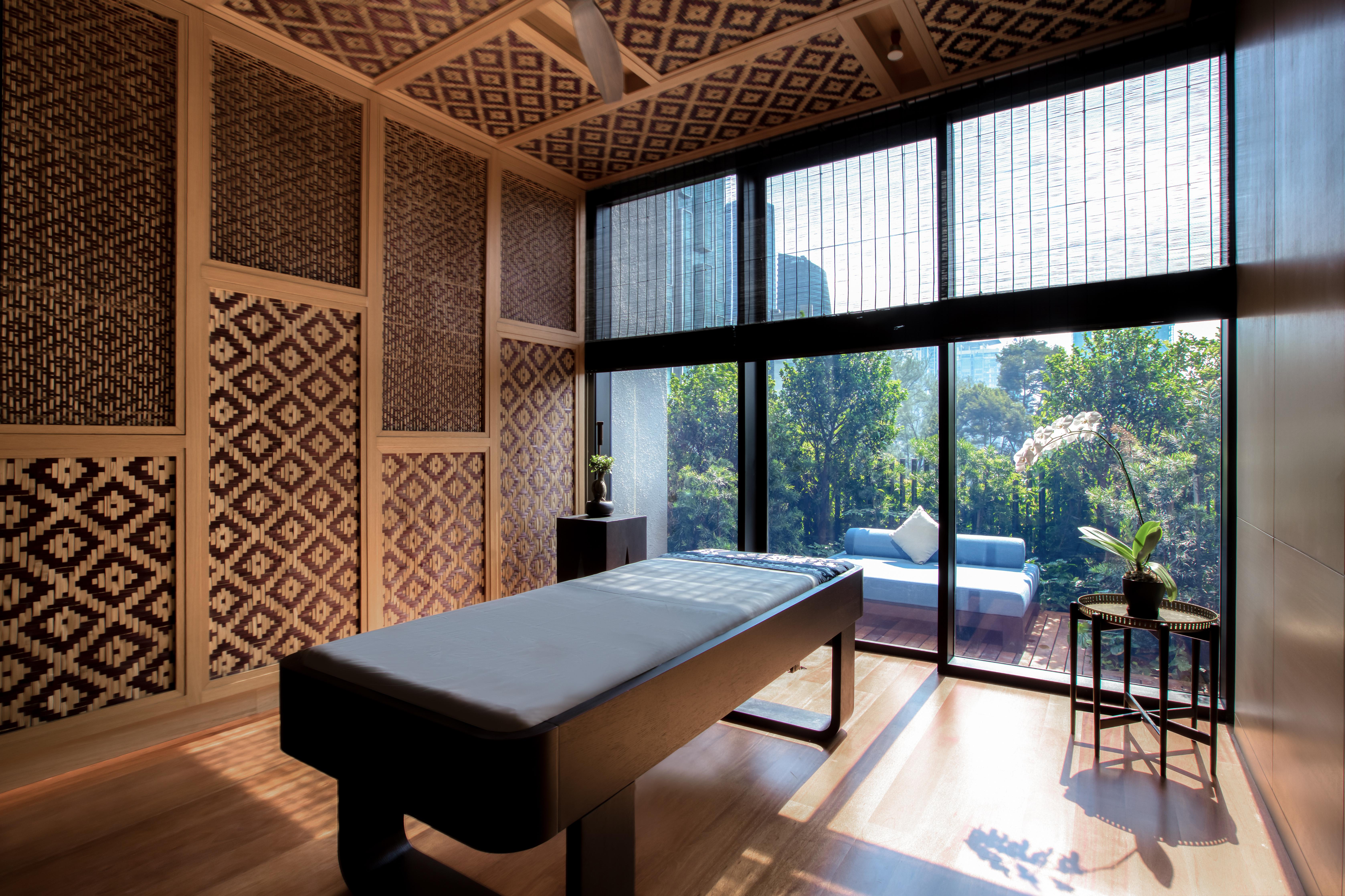 The Ruma Hotel And Residences Kuala Lumpur Exteriér fotografie The photo displays a tranquil room designed for relaxation or therapy. The room features a massage table centered in the space, with elegant wooden accents. The walls are adorned with intricate geometric patterns, contributing to a serene atmosphere.