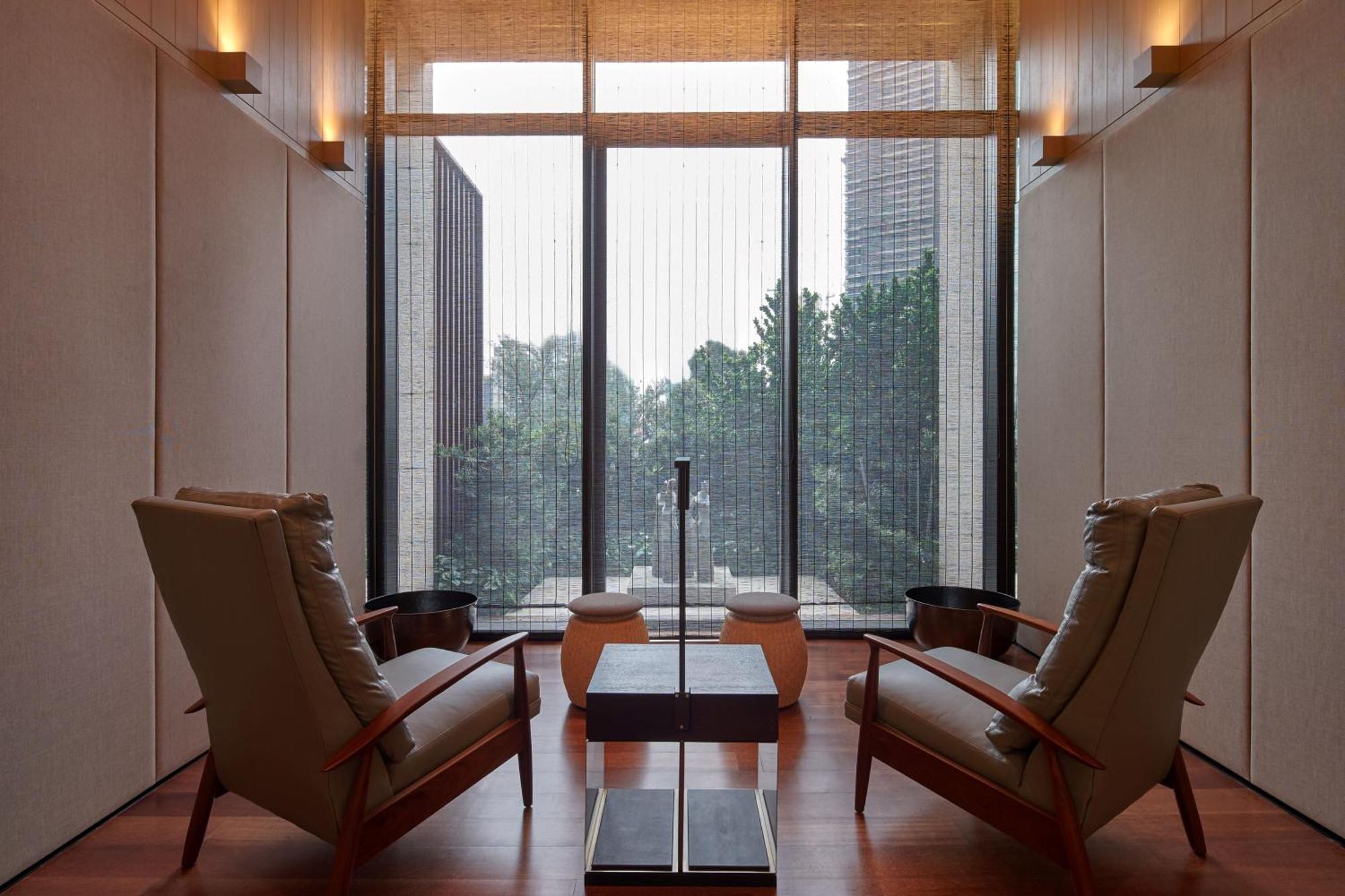 The Ruma Hotel And Residences Kuala Lumpur Exteriér fotografie The photo depicts a minimalist interior space, featuring two stylish chairs positioned across from each other. Between them, there's a sleek table with a simple design. The walls are finished with a light color, contributing to a serene ambiance. Lar